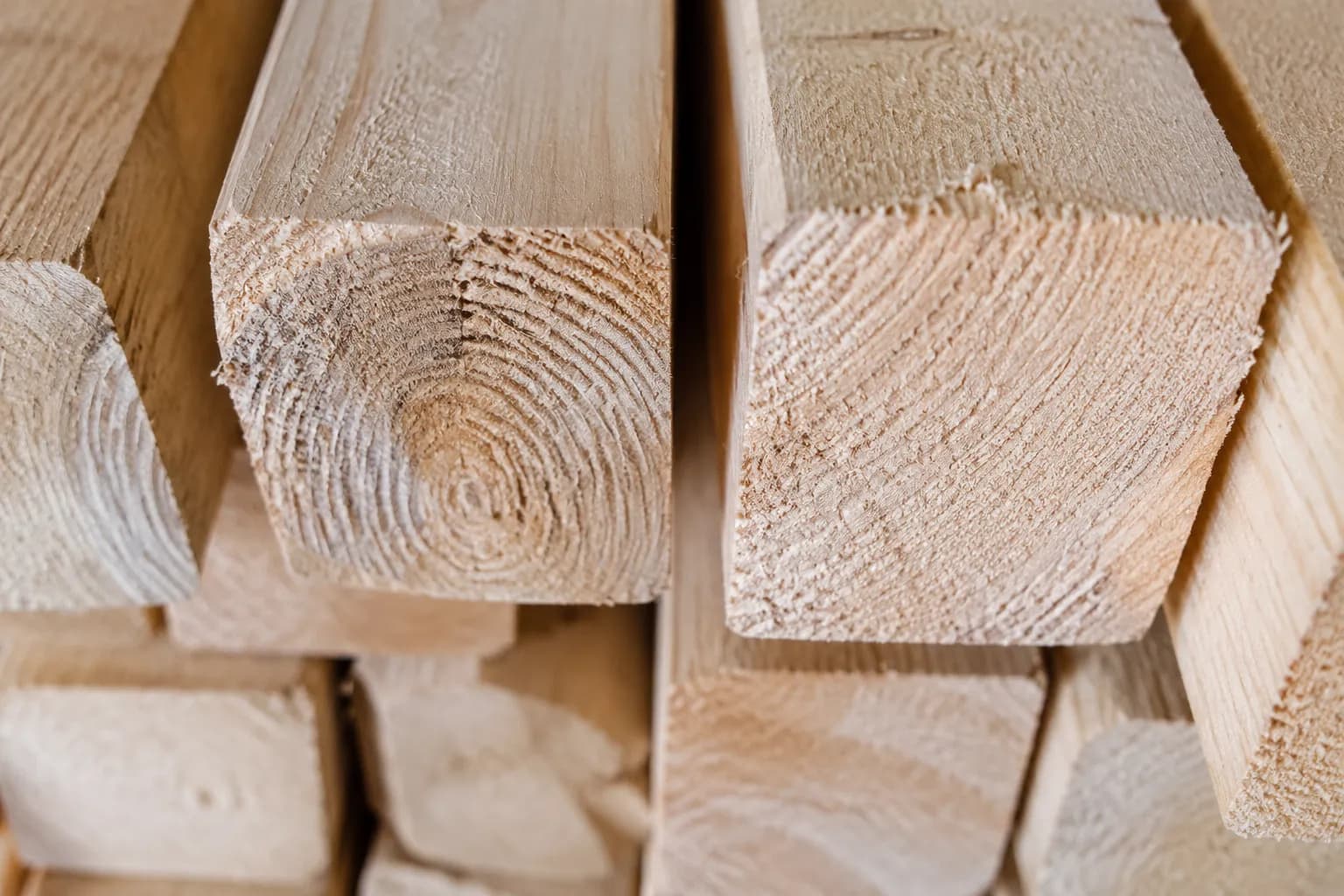 Close detail of stacked two-by-four lumber showing wood grain and cut texture