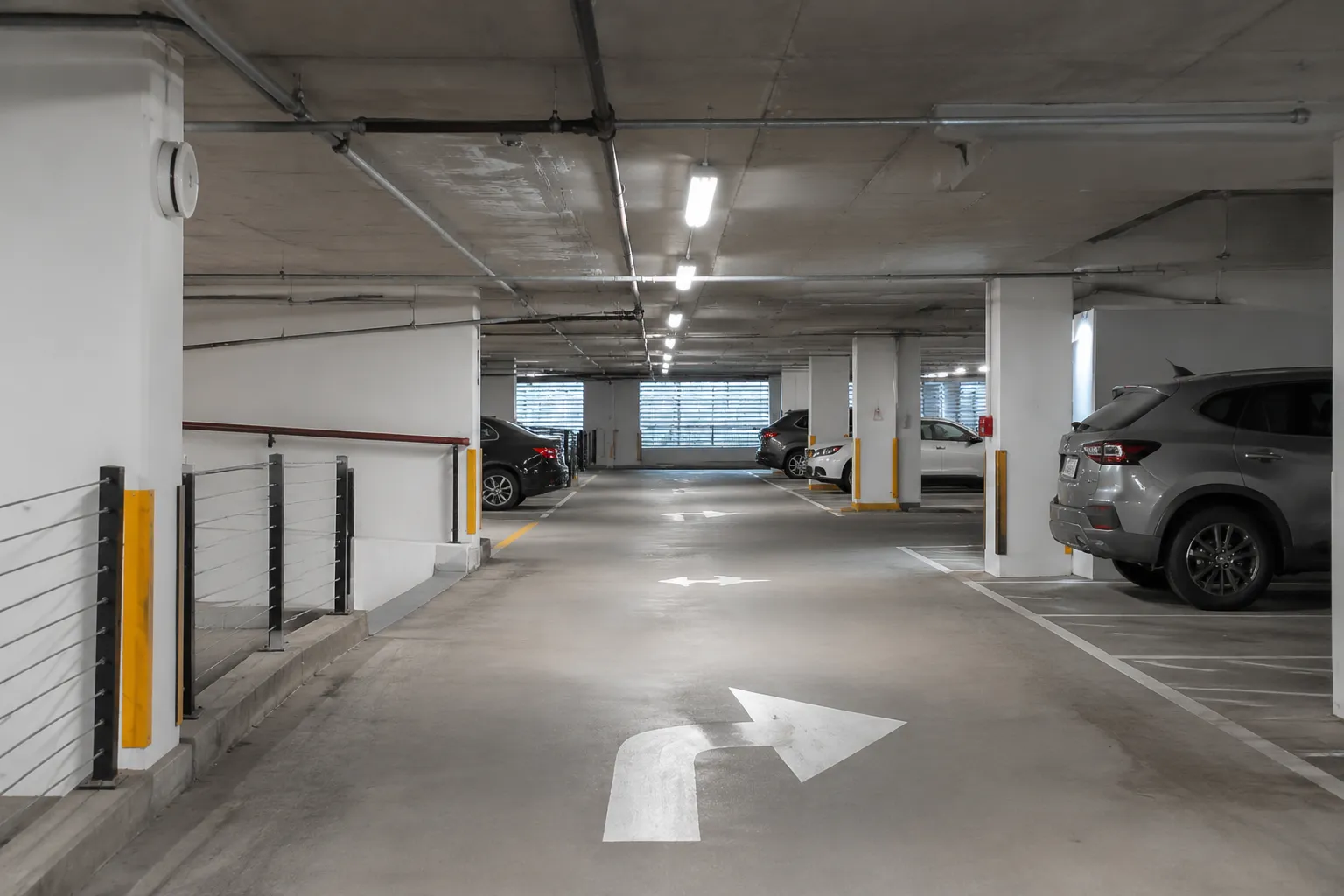 Interior of covered parking garage at Miami shopping mall with directional markings
