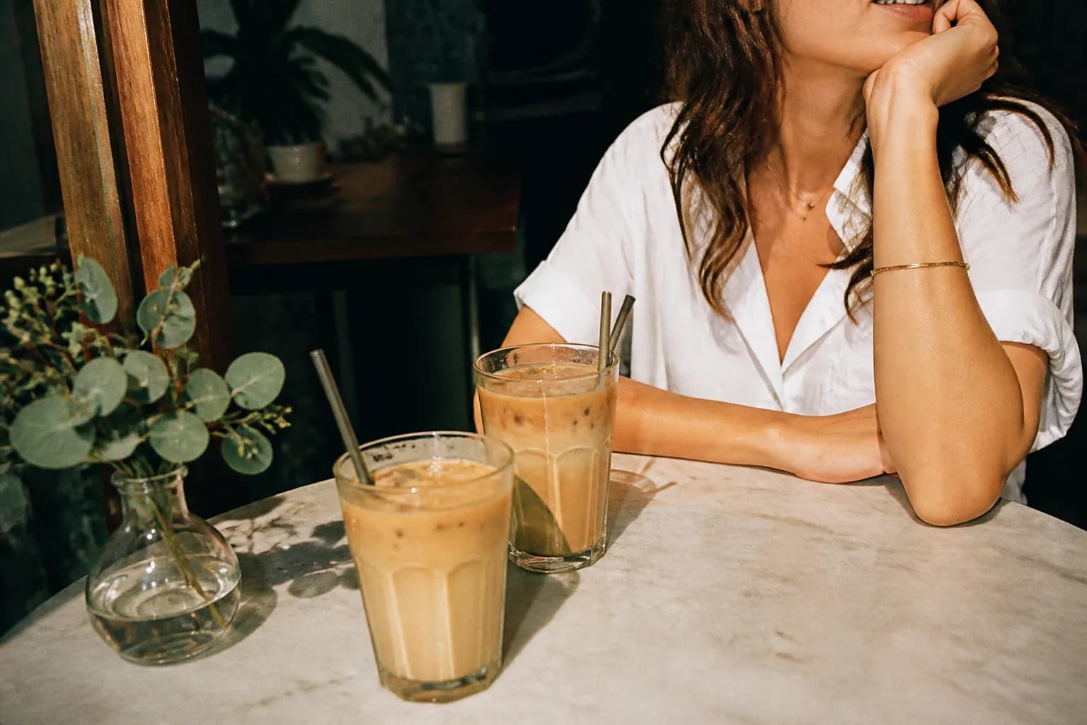 Two iced coffees on a sunny cafe table