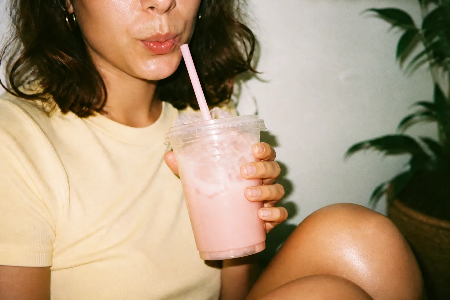 A pastel-colored iced drink in a clear cup on a counter