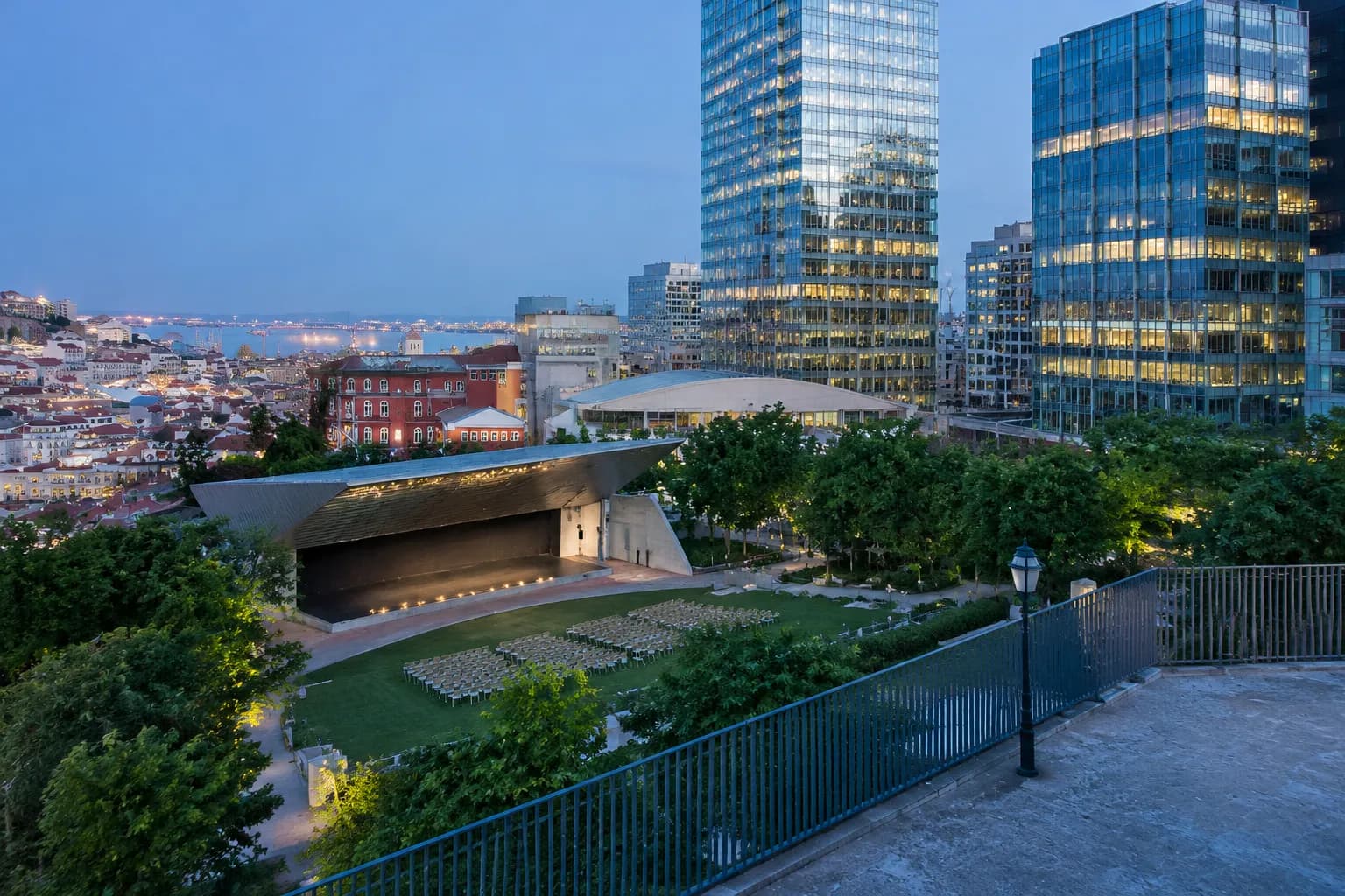 Yerba Buena Gardens outdoor stage and lawn at dusk with SoMa office towers in background