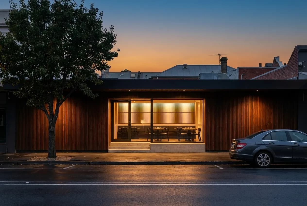 A low modern restaurant frontage on a wide boulevard in Mid-City at dusk
