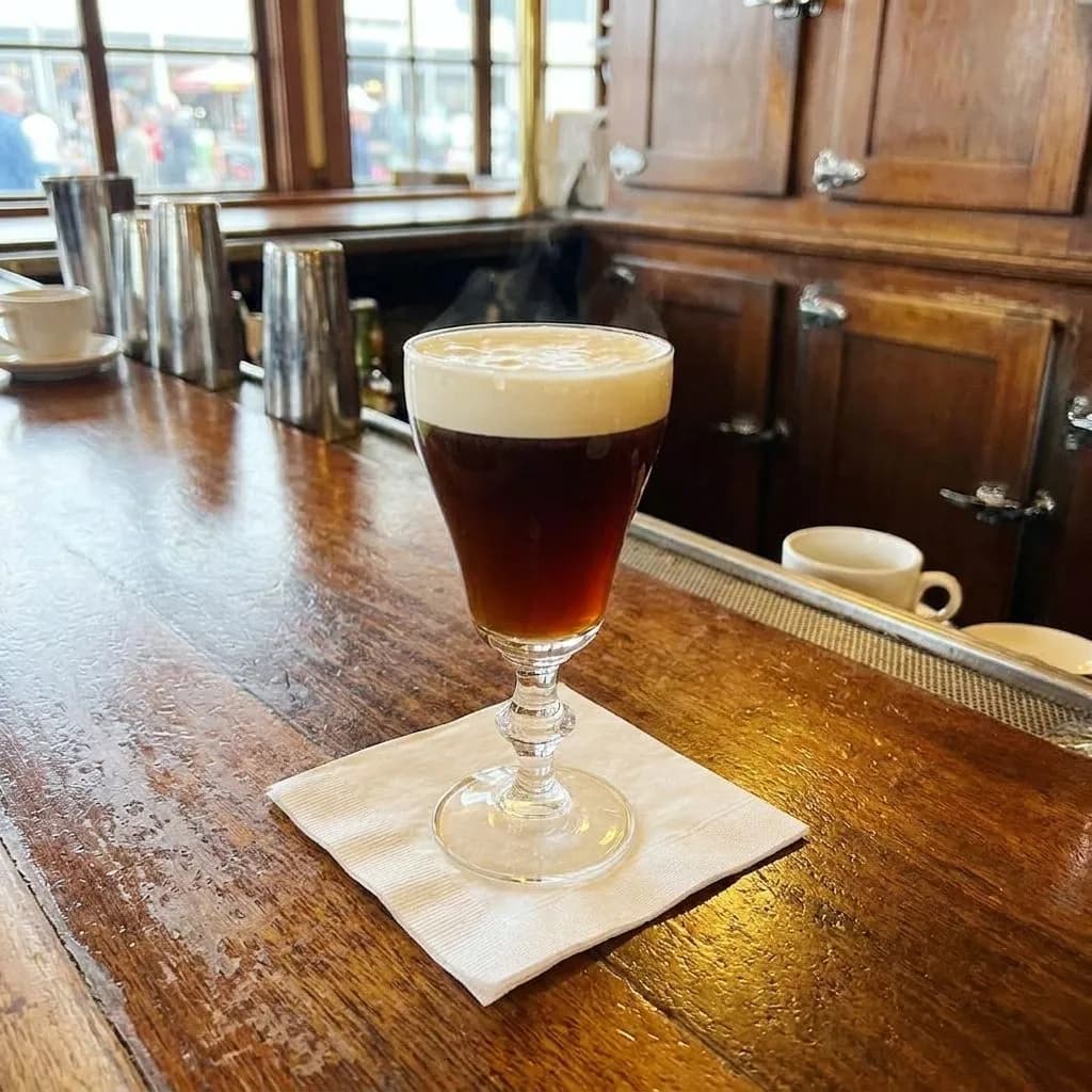 An Irish coffee on the counter at The Buena Vista with Wharf light outside.