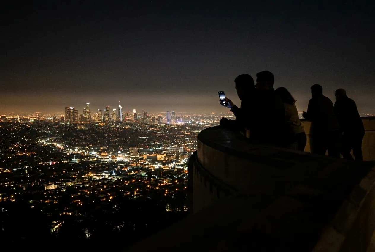 The Los Angeles basin seen at night from the Observatory's terrace, visitors silhouetted along the parapet