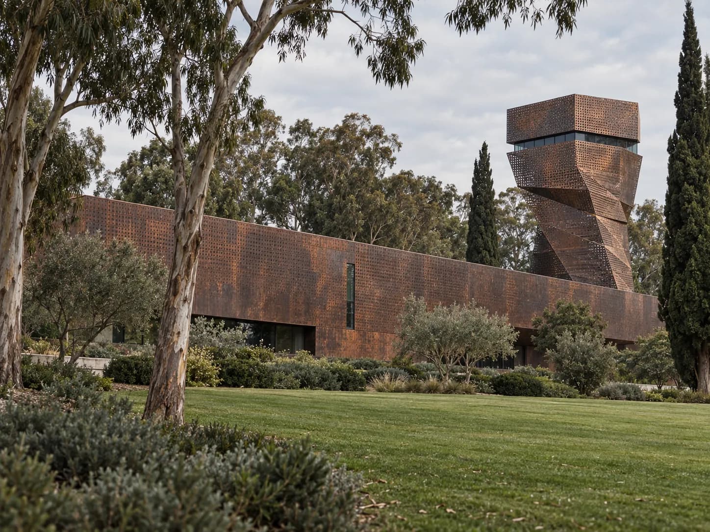 A copper-clad museum building weathered to brown among tall trees