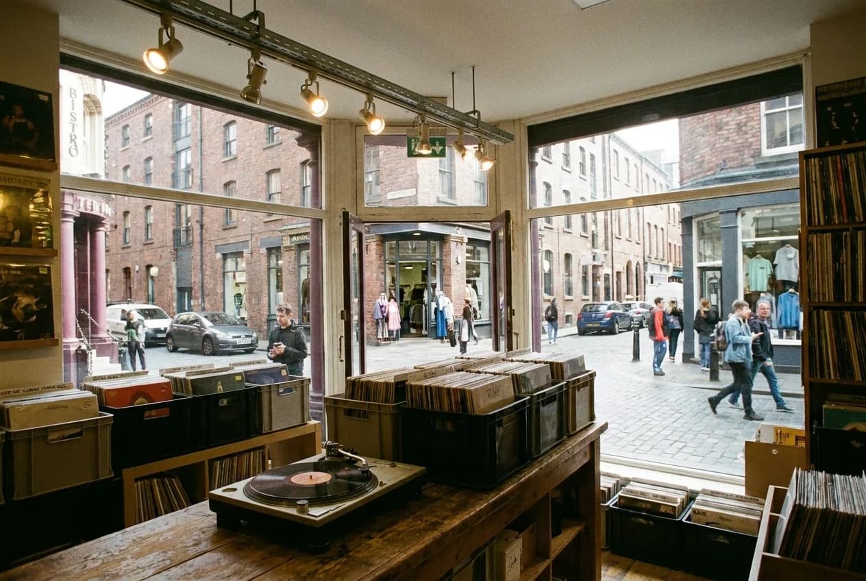 Vinyl records in crates beside a turntable on a shop counter