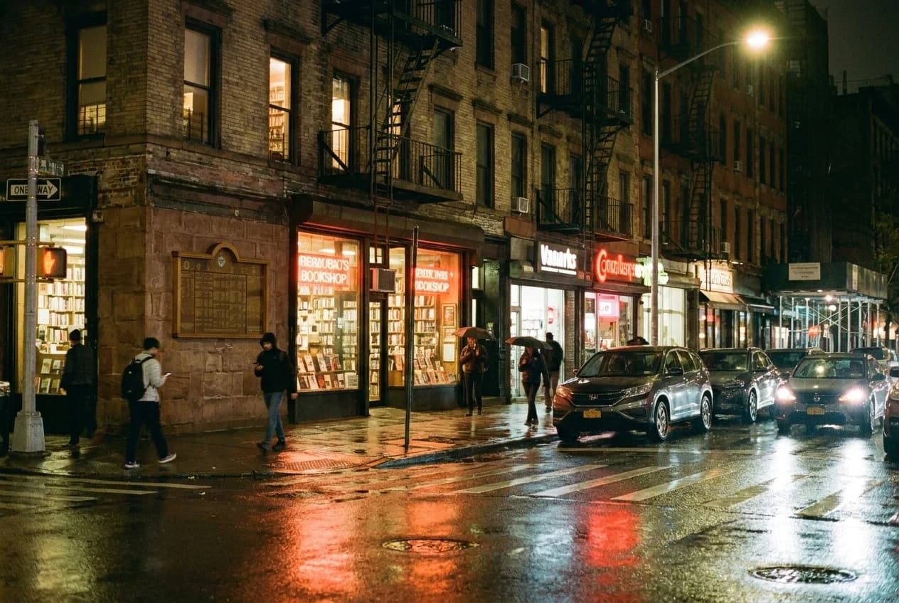 Wet pavement reflects neon signs on St. Marks Place in the East Village at night