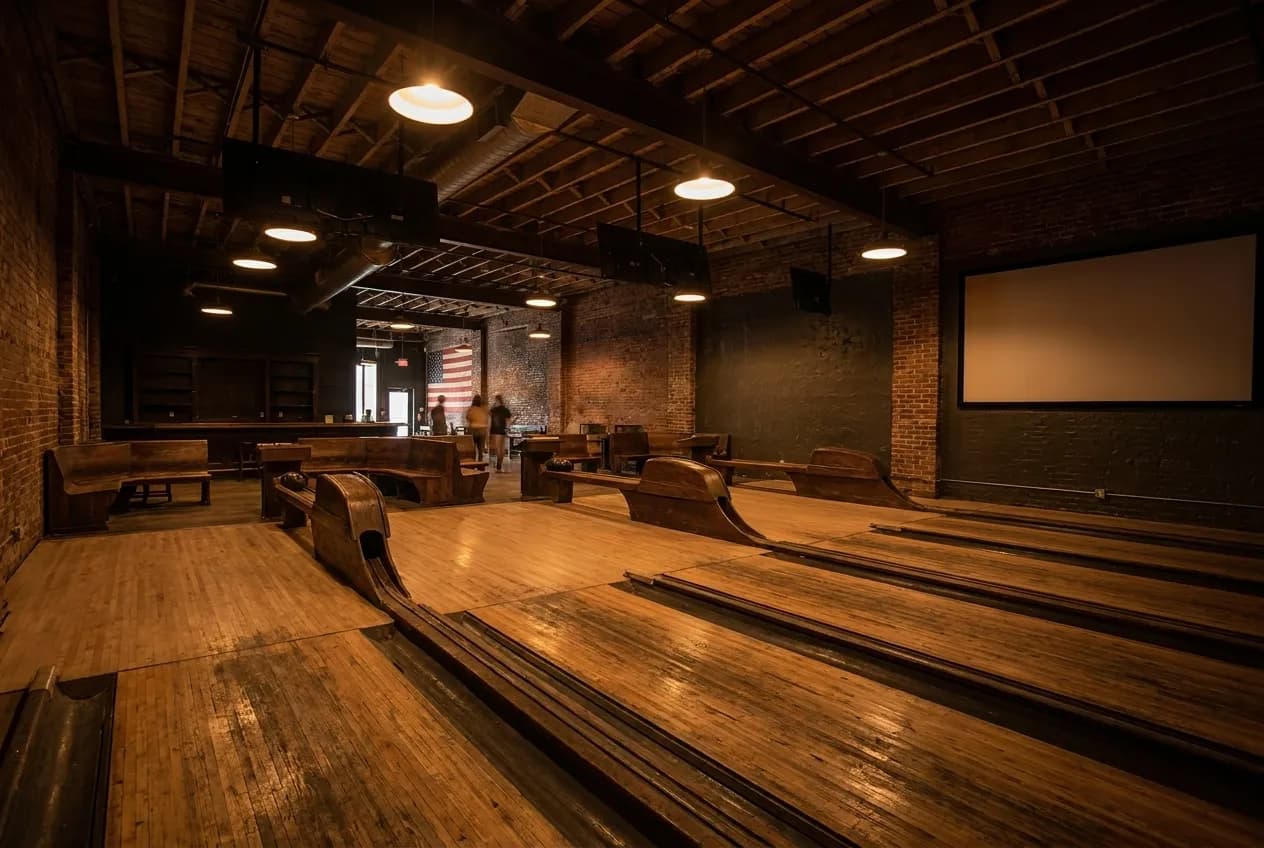 Vintage wooden bowling lanes under low warm lighting inside an old hall