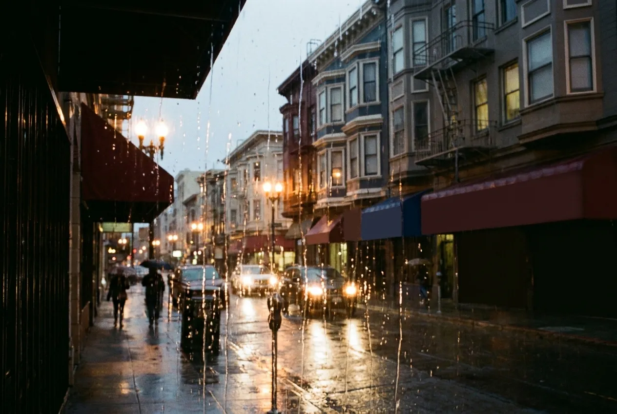 A rain-streaked window looking out onto a grey city street