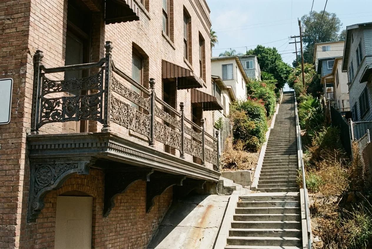 A long flight of concrete public stairs climbing between hillside houses and greenery in Los Angeles