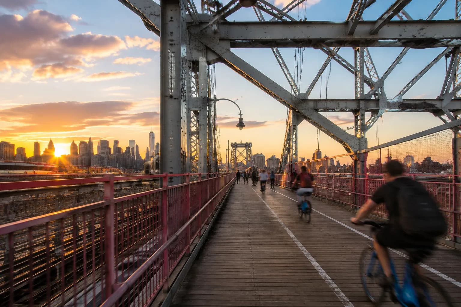 Pedestrian walkway on the Williamsburg Bridge looking toward Brooklyn with Manhattan skyline in the distance
