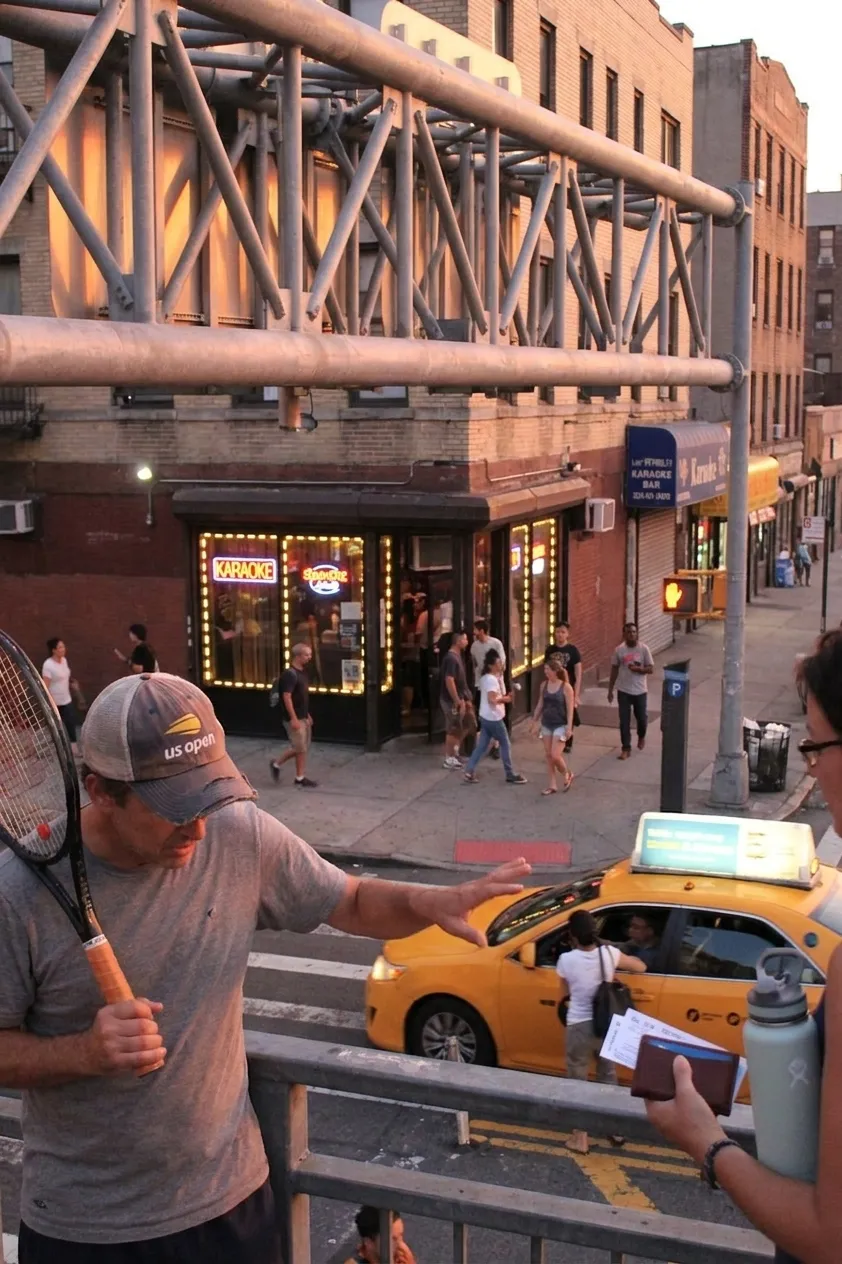 A bright Queens local-life scene inspired by astoria queens street night, with subtle US Open details.