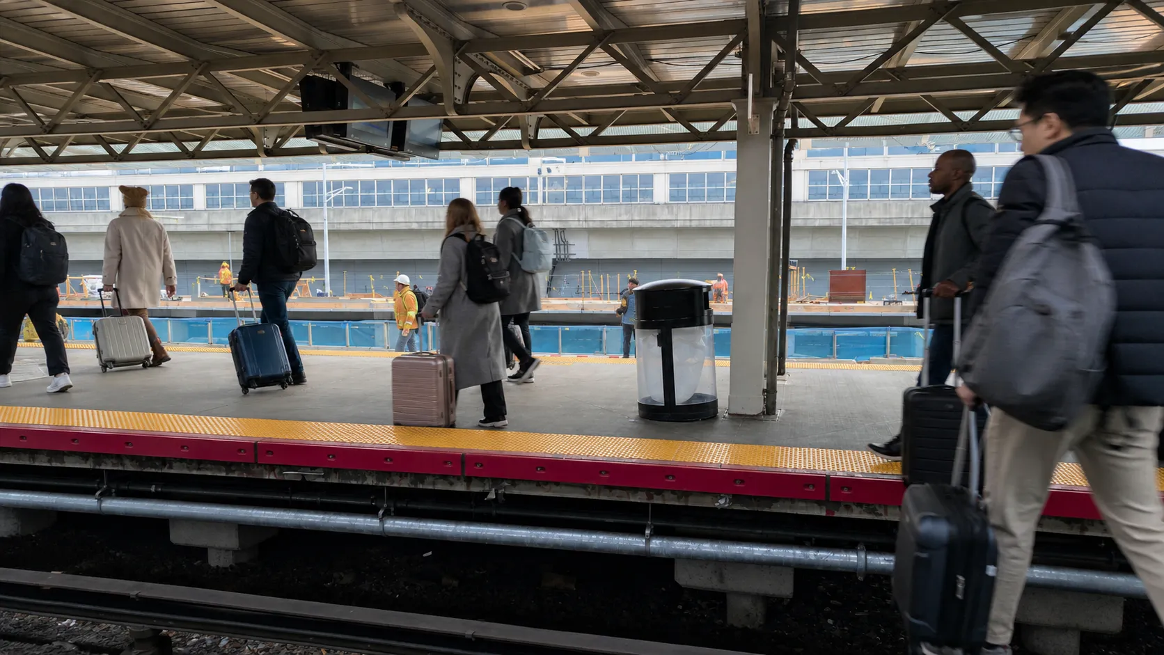 Airport passengers use rail transit while adjusting plans after a flight diversion in New York.
