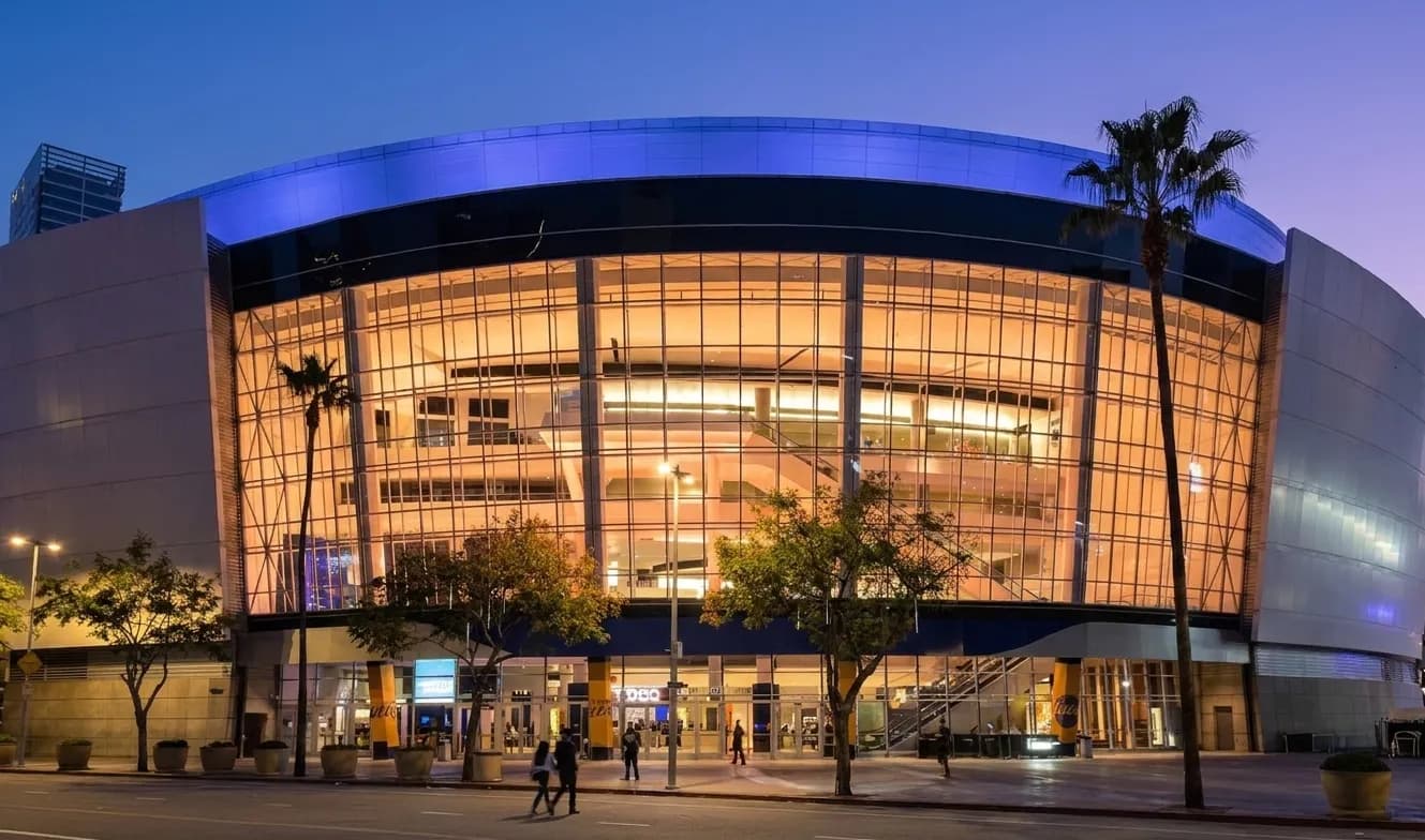 Exterior of Crypto.com Arena in downtown Los Angeles with its distinctive curved glass facade and plaza in the foreground