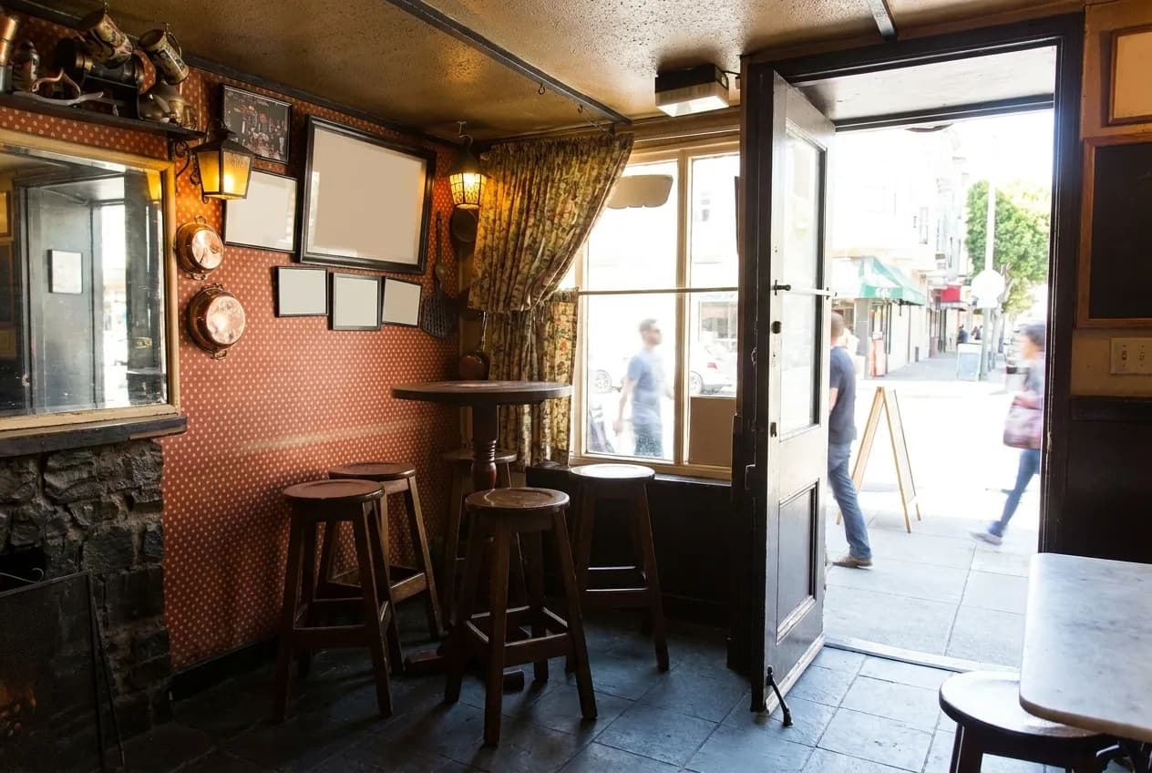 A pub interior in daylight with the front doors open onto the pavement