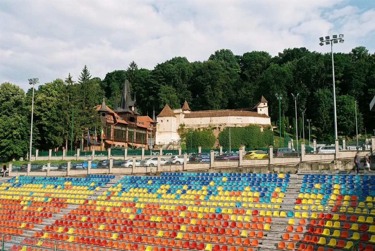 A stadium concourse with empty seats and floodlights above