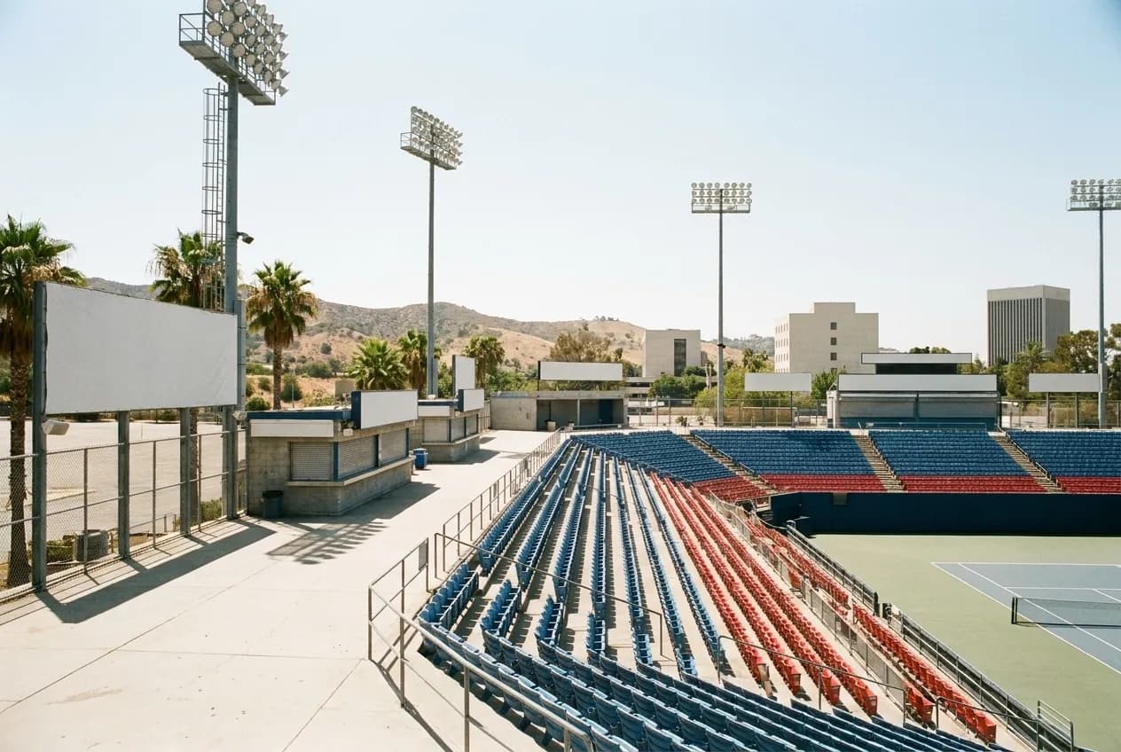 A stadium concourse with empty seats and floodlights above