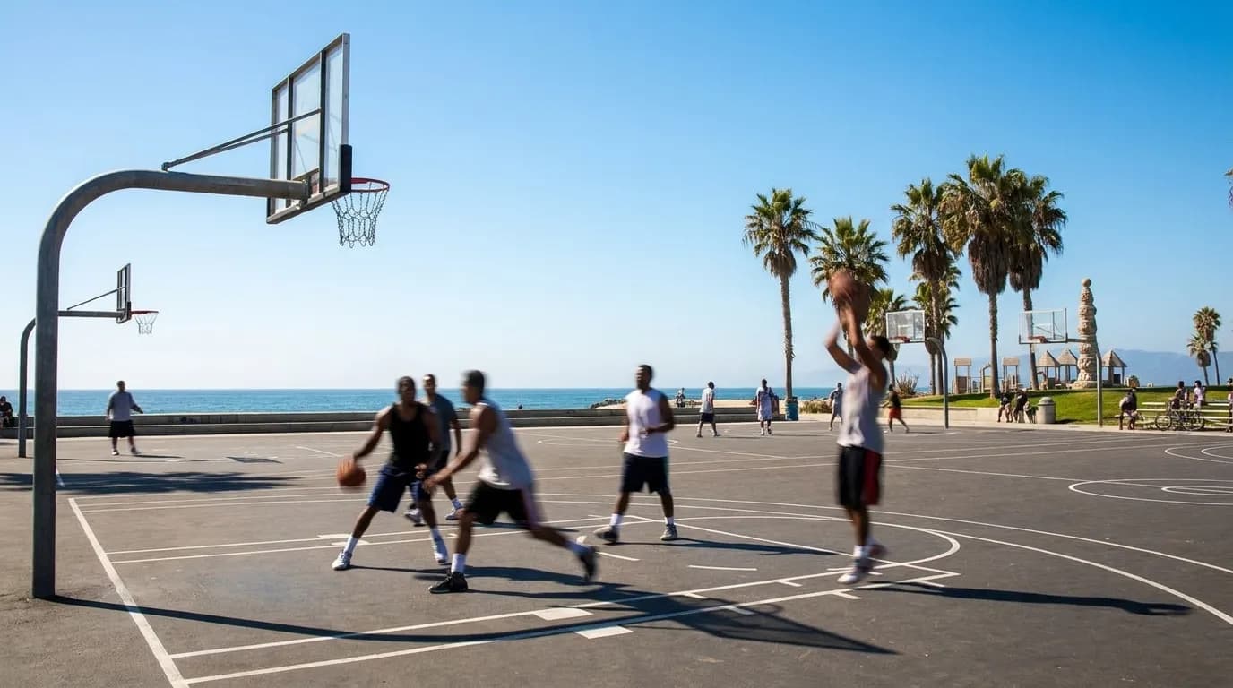 Outdoor basketball courts at Venice Beach with chain nets and ocean in background