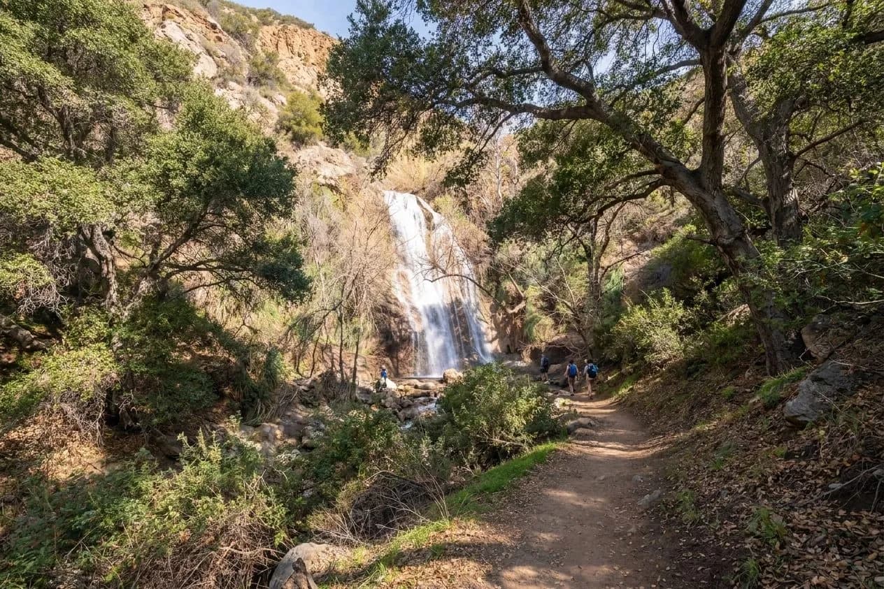 A winding canyon trail in Malibu leading toward a distant waterfall