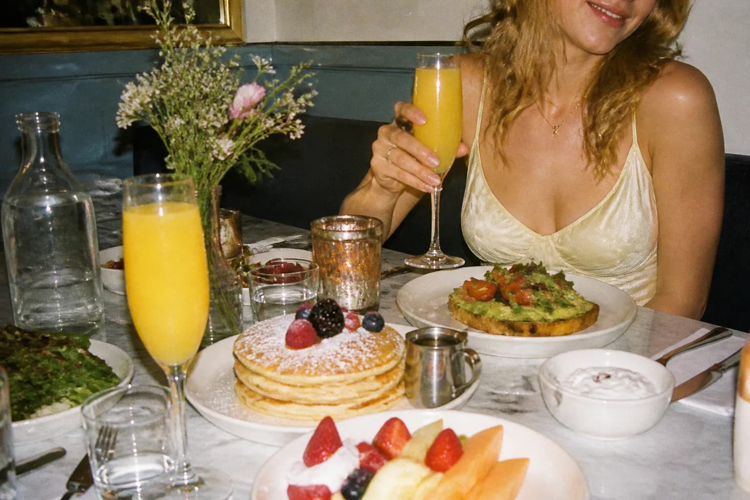 A bright brunch spread with pancakes and drinks on a sunlit table