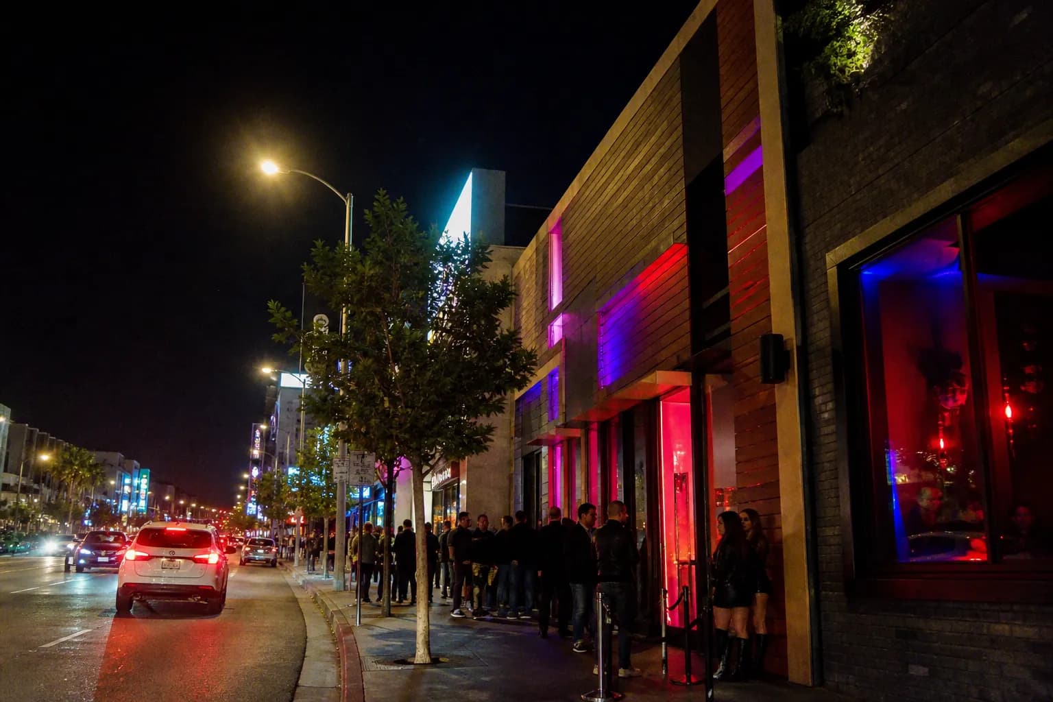 Neon-lit West Hollywood nightlife street outside a live music bar at night