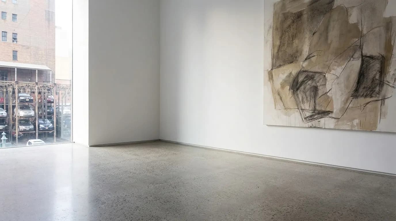 Minimalist contemporary art gallery interior with white walls and natural lighting from large windows