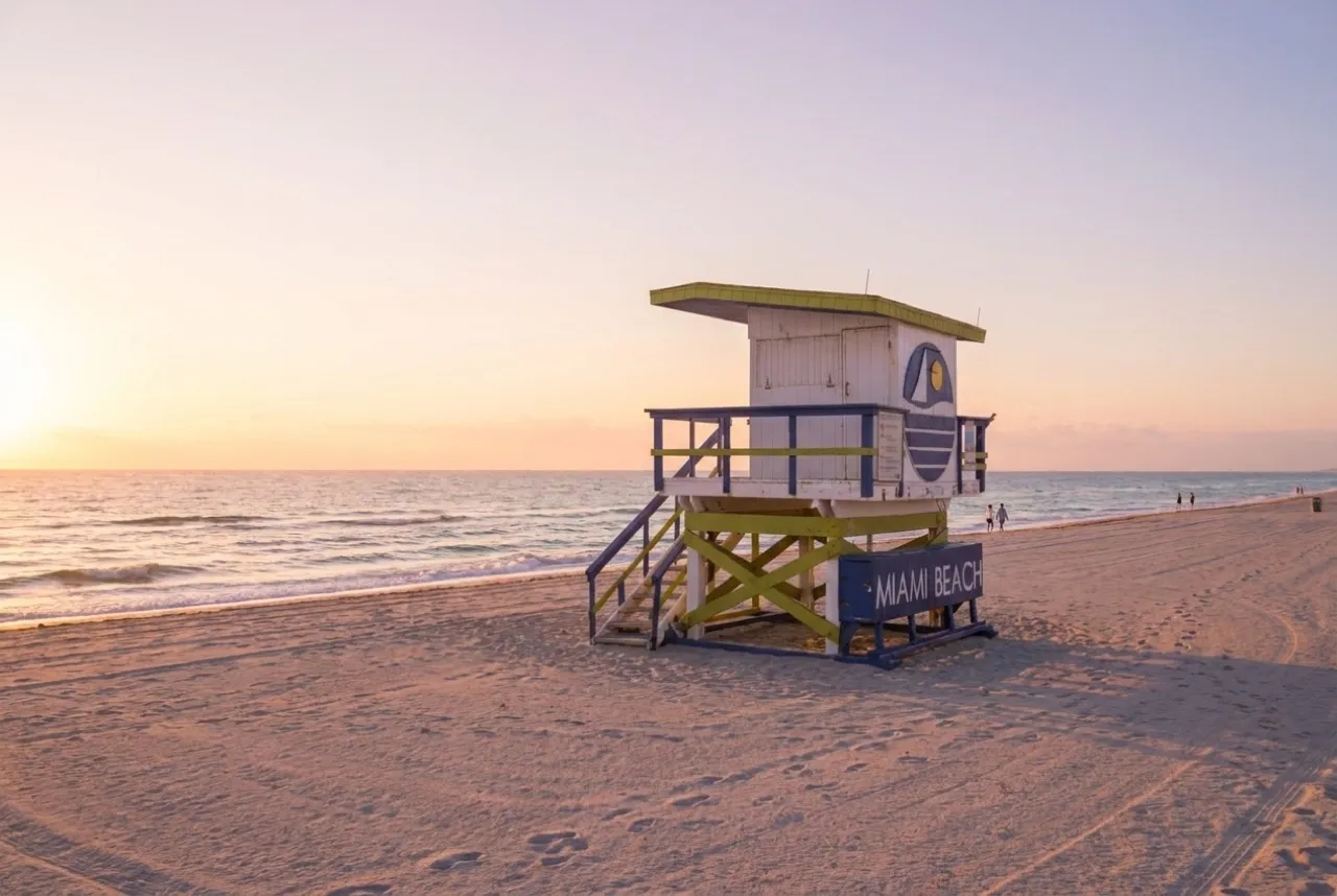 Pastel lifeguard tower on South Beach at sunrise with wide empty sand
