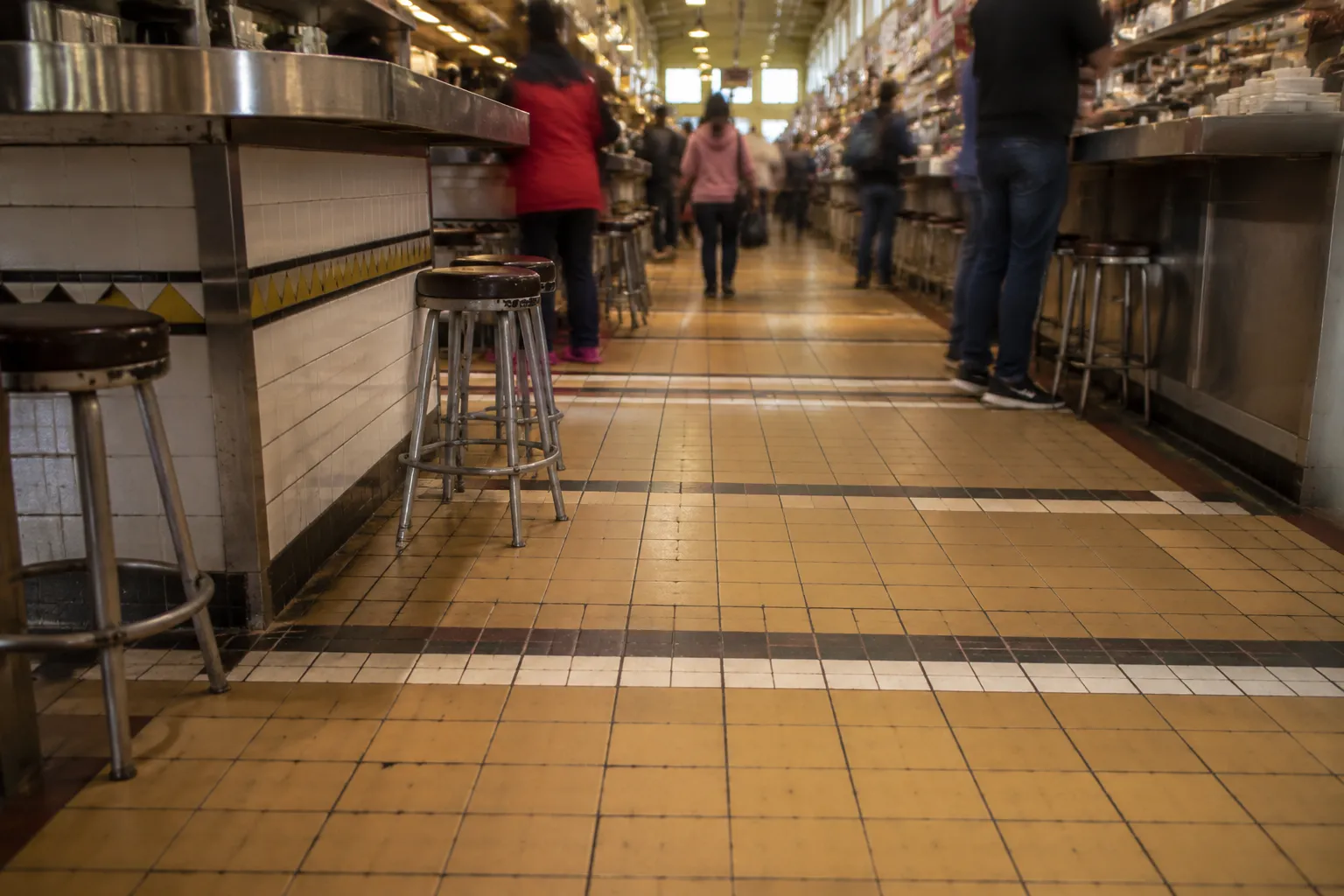Interior view of Grand Central Market showing historic tile floors and vendor stalls under natural light
