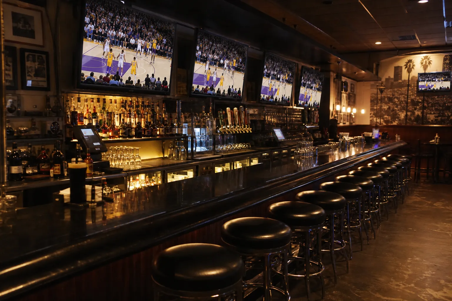 A Los Angeles sports bar interior with multiple televisions and empty stools before tipoff