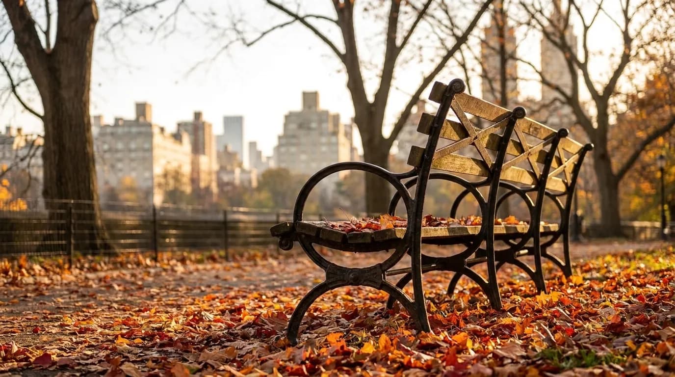 Central Park West in autumn with pedestrians walking beneath golden trees along the park edge