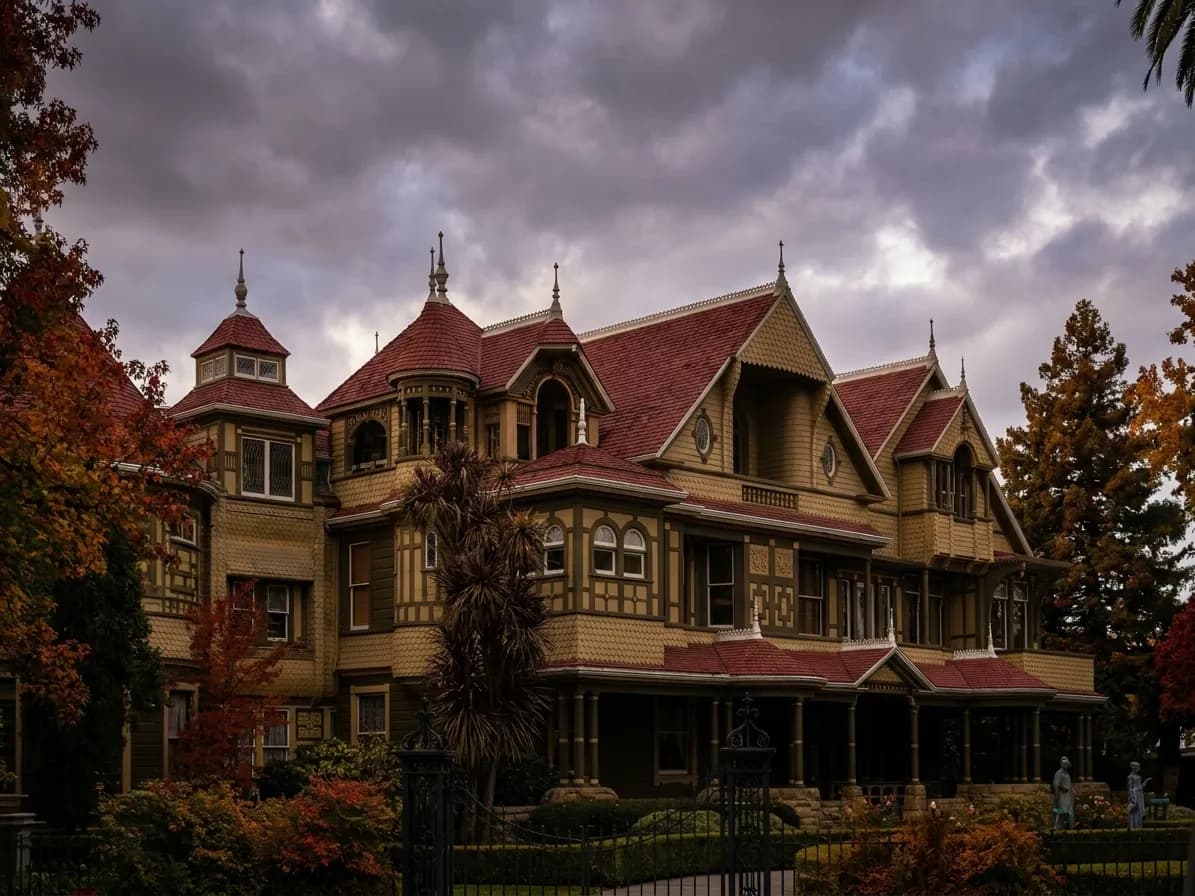 Victorian mansion facade of Winchester Mystery House with ornate towers and gables behind iron gates in San Jose