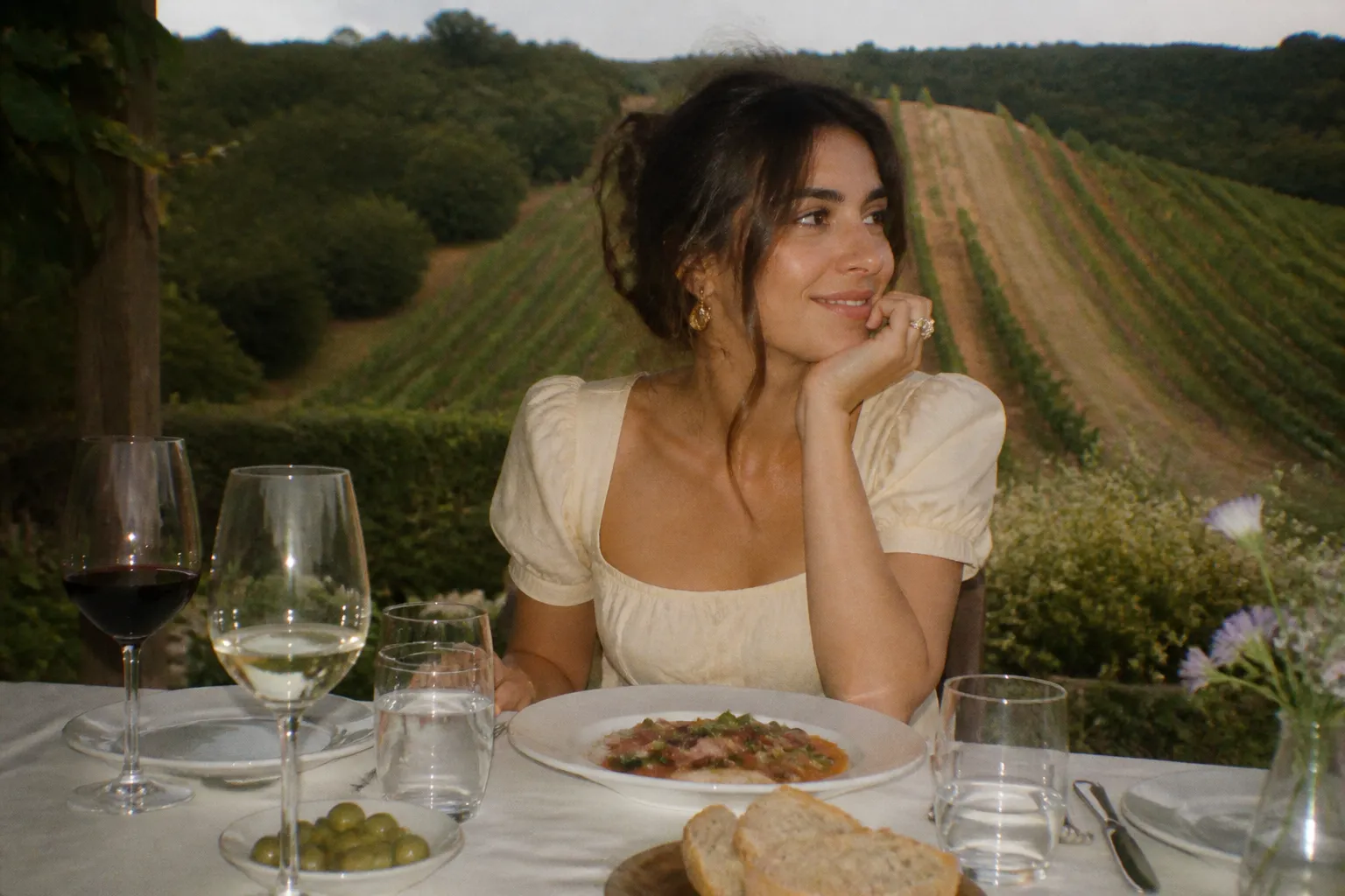 An elegant table set with a glass of wine and a plated dish at a vineyard restaurant