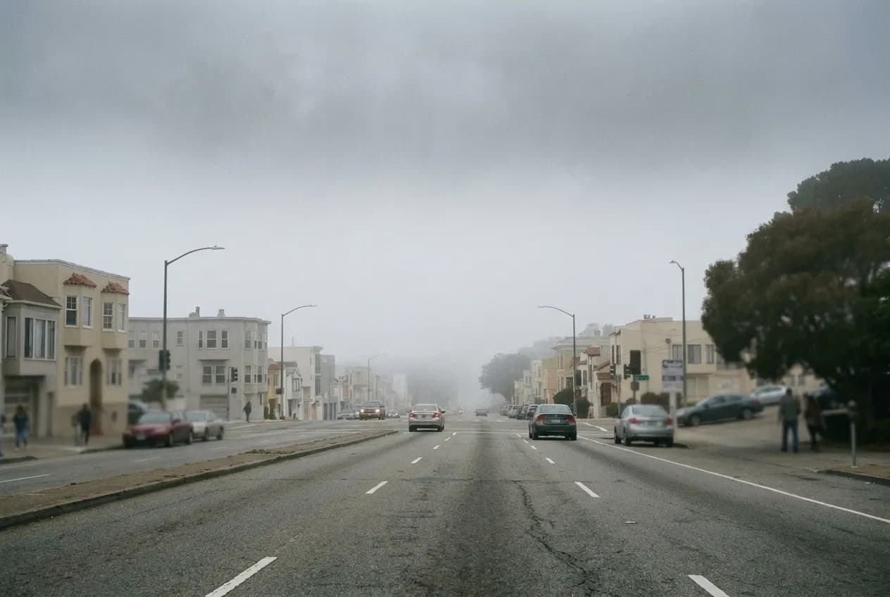 A wide residential street in San Francisco's Outer Sunset running towards the ocean in low fog