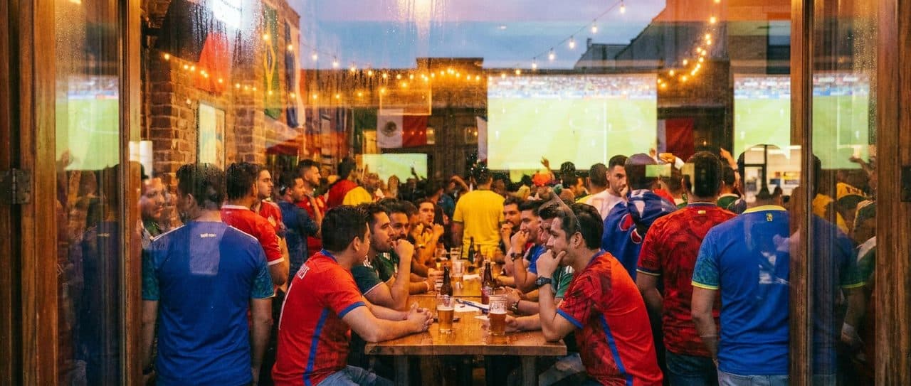 Woodside Bars During the FIFA World Cup 2026, Crossed Flags and a Shared Table scene