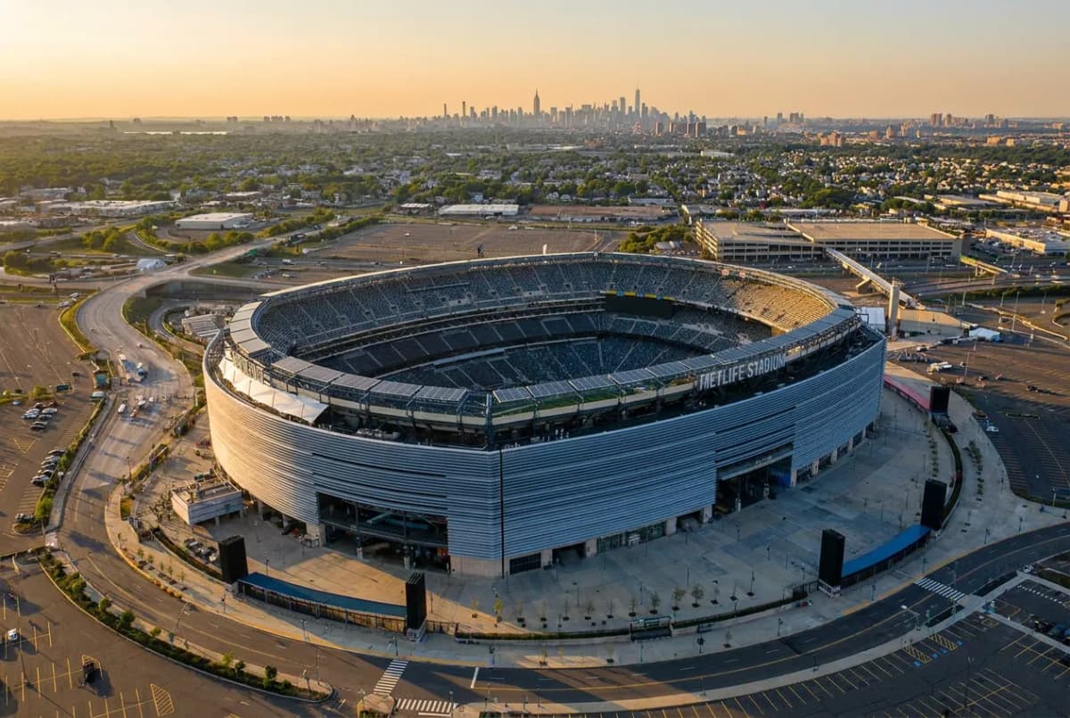 Aerial view of MetLife Stadium in the New Jersey Meadowlands at golden hour with the Manhattan skyline behind it