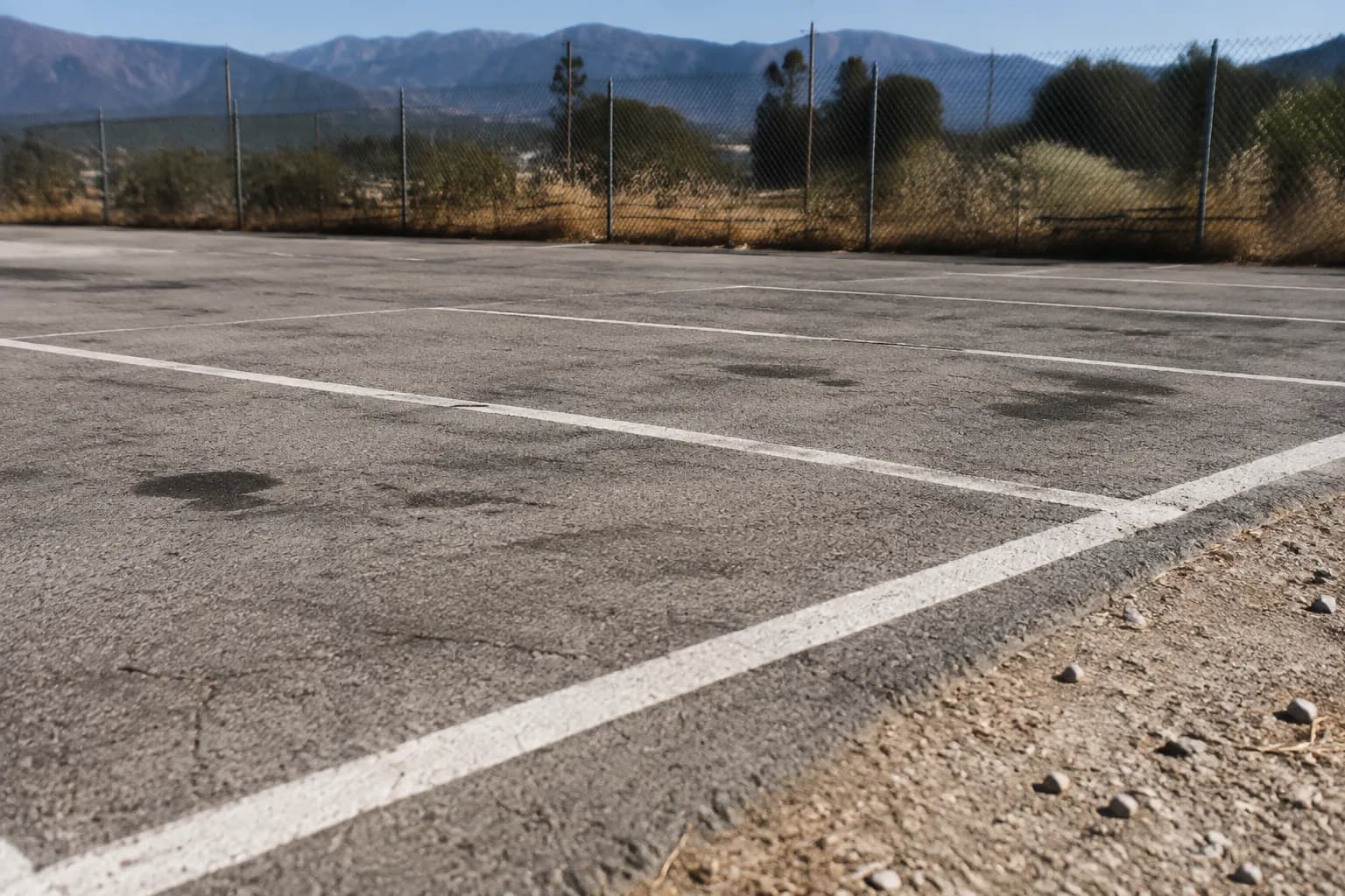 Dusty parking lot at Irwindale Speedway with San Gabriel Mountains in the distance