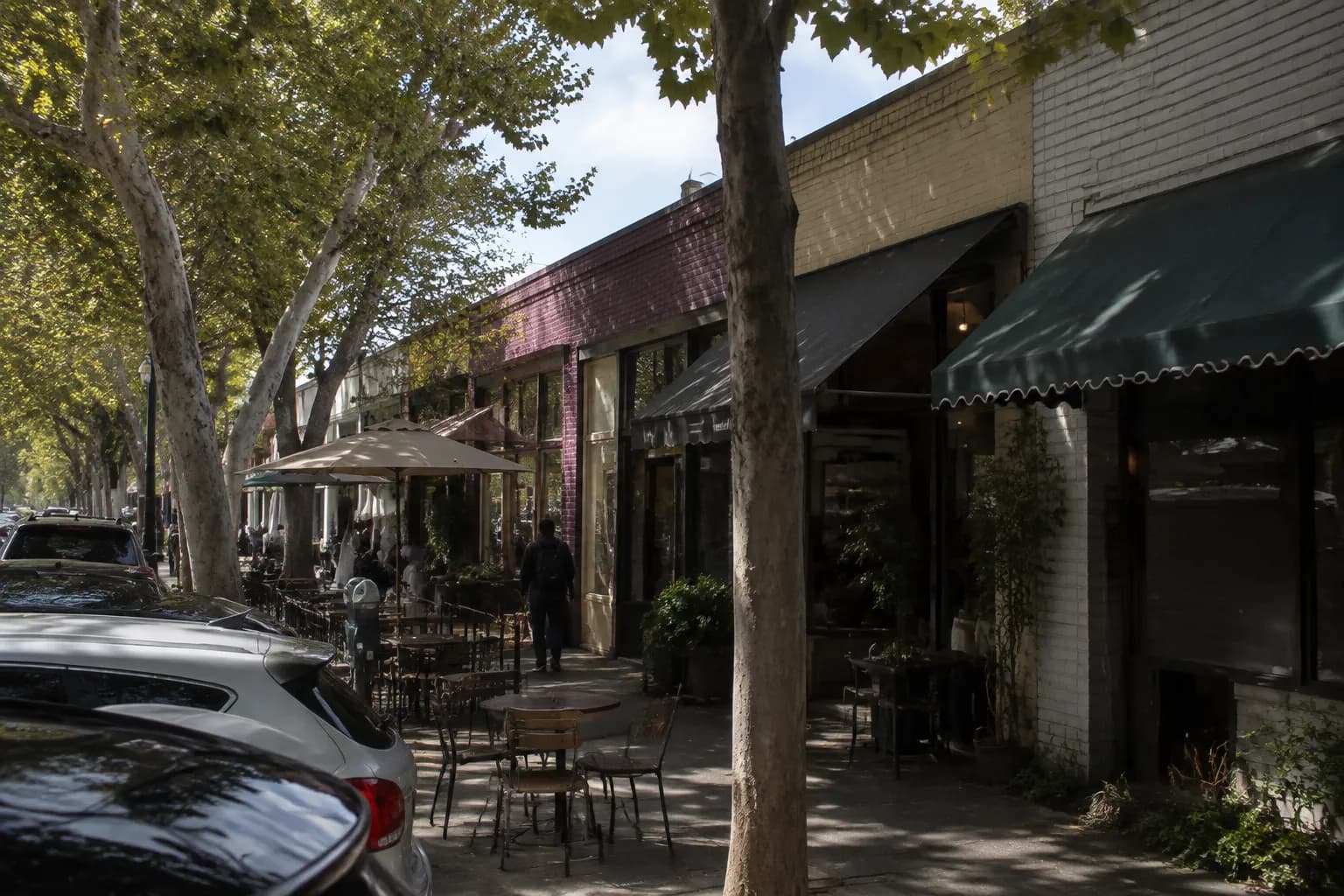 York Boulevard in Highland Park with storefronts, street trees, and outdoor seating on a weekend afternoon