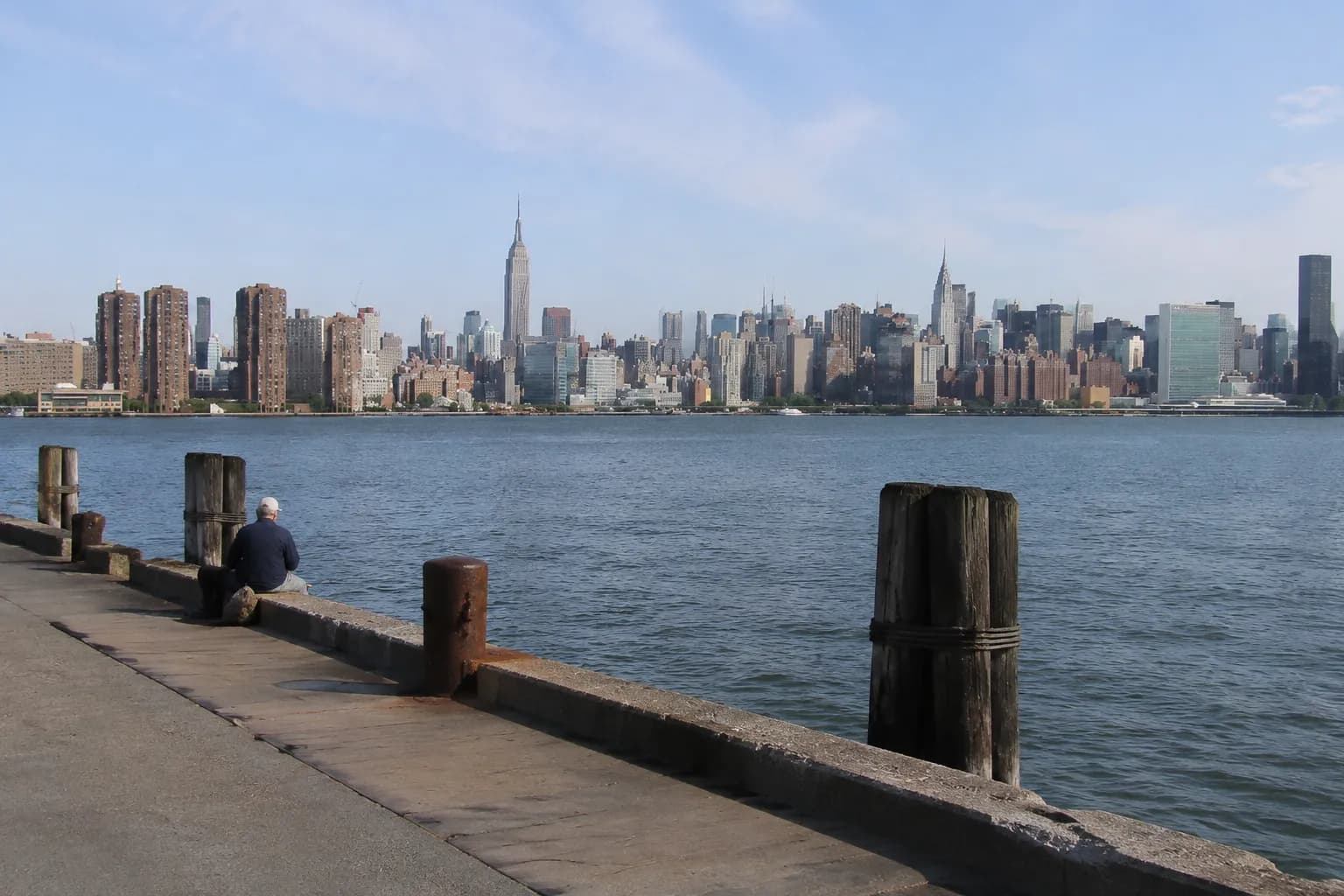 View across the East River from Greenpoint waterfront toward the Manhattan skyline in morning light
