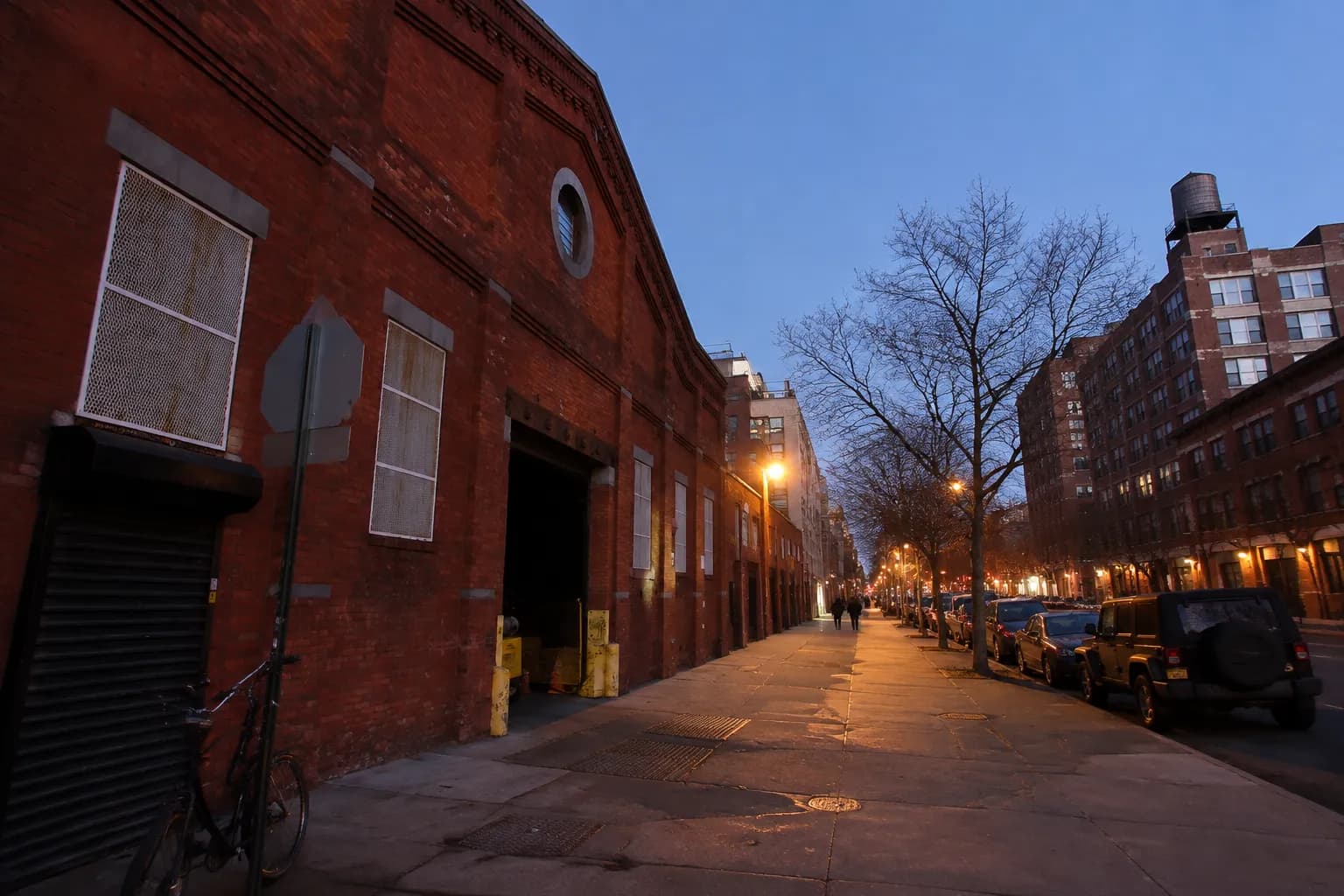 Wythe Avenue in Williamsburg at dusk with brick warehouse buildings and empty sidewalk