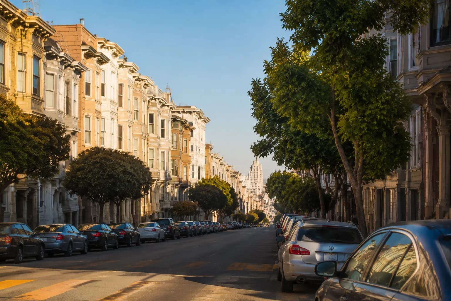 Fillmore Street in San Francisco's Western Addition, lined with Victorian homes and street trees under afternoon light